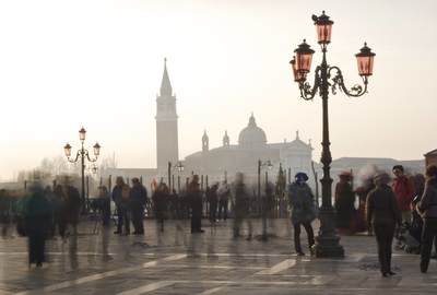 Last morning of the Carnival in Piazetta San Marco with photographer and carnival entrants posing,  facing the Guidecca and the Church of San Giorgio Maggiore at Dawn in Venice, Italy Europe