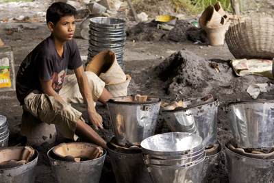 A boy helps create the traditional terracotta 'stoves' used by Cambodians to cook food and heat water, at an artisans village near Kampong Chnang (Chhnang) on the Tonle Sap river in Cambodia