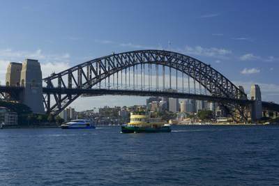 View of the metal Sydney Harbour bridge seen from water on a sunny morning, in New South Wales in Australia