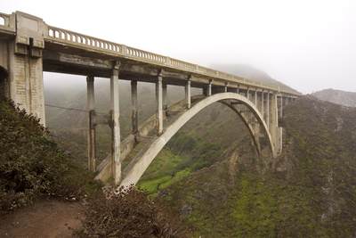 Rocky Creek Bridge viewed in thick sea fog, a reinforced concrete open-spandrel arch bridge, built in 1932, situated on the 'Big Sur' (California Highway 1) in California in the United States of America USA U.S.A.