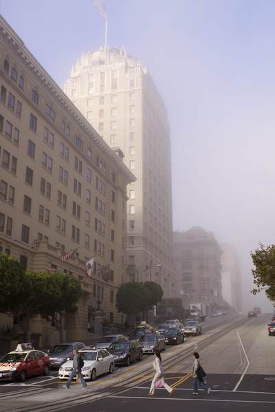 Early Autumn morning fog obscures the tops of buildings on California Street, viewed from the intersection with Powell Street in San Francisco in California in the United States of America USA U.S.A.