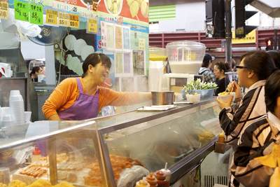 Children from Queen Elizabeth School buy lunchtime snacks from a Chinese street stall on Nathan Road on the Kowloon Peninsula in Hong Kong
