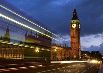 Slow exposure of passing buses on Westminster Bridge over the river Thames by the Houses of Parliament in central London in the United Kingdom