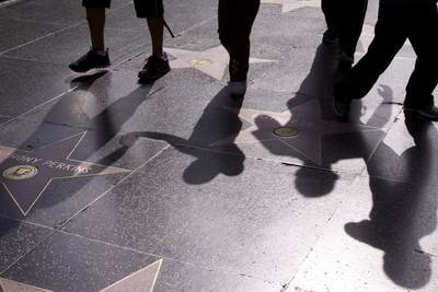 People walking on the 'Hollywood Walk of Fame' which consists of more than 2,400 five-pointed terrazzo and brass stars embedded in the paths (sidewalks) along the Hollywood Boulevard in Los Angeles, California, United States of America USA U.S.A.