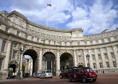 A red mini drives towards Admiralty Arch in central London in the United Kingdom