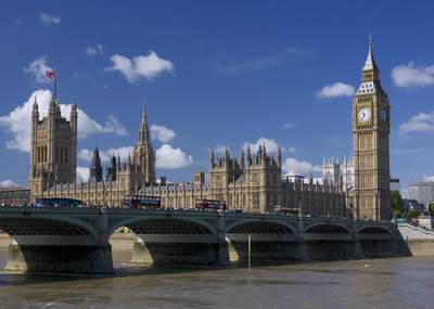 Passing buses on Westminster Bridge over the river Thames by the Houses of Parliament in central London in the United Kingdom