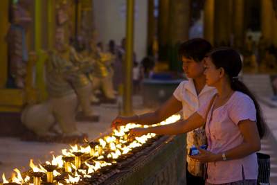 Visitors to the Shwedagon Pagoda complex light votives in a ring around the central Zedi (stupa) (Shwedagon Zedi Daw in Yangon (Rangoon) in Myanmar (Burma)