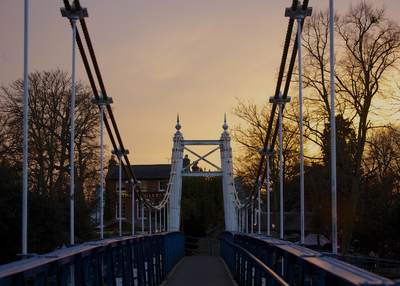 Sunset view along the Teddington footbridge towards the Anglers pub in Teddington in Middlesex in the United Kingdom