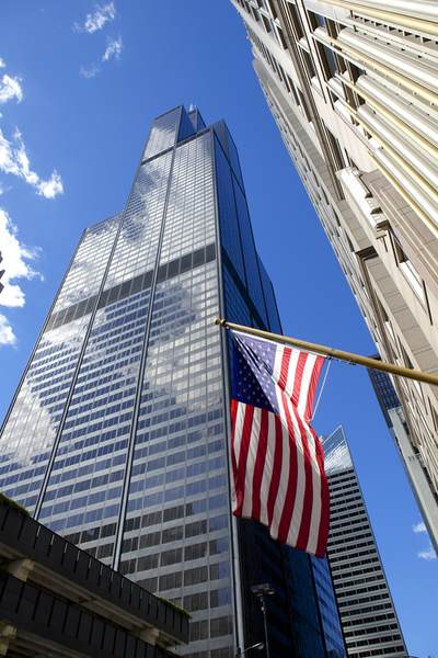 The American flag flies in front of the Willis Tower (a.k.a. Sears Tower) on 233 South Wacker Drive, completed in 1973 and currently the second tallest building in the United States in Chicago (Windy City) in Illinois in the United States of America USA U.S.A.