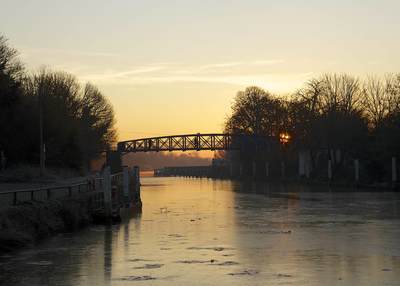 The river Thames frozen in Winter by Teddington footbridge at dawn in Middlesex in the United Kingdom