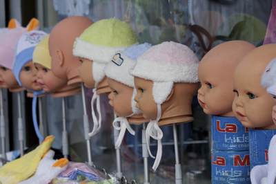 A line of decapitated dolls used to model knitted baby hats and bonnets on a stall outside the Grand Bazaar in Istanbul, Turkey in Europe