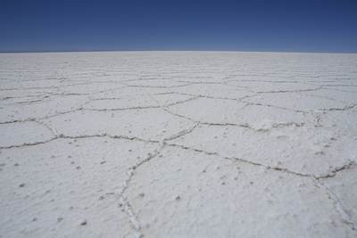 The bright white surface of the Salar de Uyuni - the worlds largest salt flats, over 10 meters thick in the centre forming hexagonal shapes in the dry season, originally formed from prehistoric inland lakes in Bolivia in South America