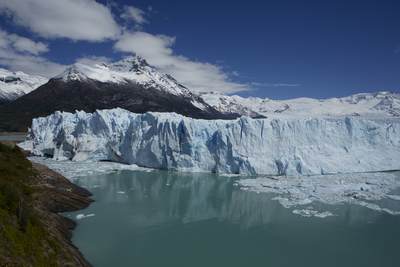 View down onto the north face of the Perito Moreno glacier and the Lago Argentino lake with ice and small icebergs in the water, created when the glacier calves in the Los Glaciares National Park in Argentina in South America