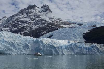 View from a boat of the ice face of the Spegazzini Glacier reflected in the water of Largo Argentino in Los Glaciares National Park in Argentina in South America