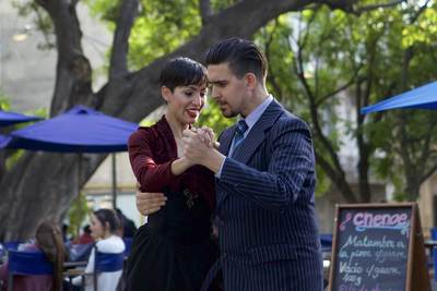 Two Tango dancers demonstrate classic dance moves outside in Plaza Dorrego and entertain onlookers, in the San Telmo district of Buenos Aires in Argentina South America