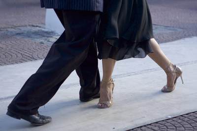 Two Tango dancers demonstrate classic dance moves outside in Plaza Dorrego and entertain onlookers, in the San Telmo district of Buenos Aires in South America
